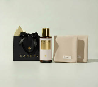 Canopy branded bottle, black gift bag, and beige pouch on a light background