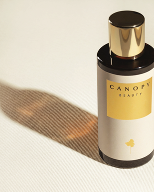 Canopy Beauty bottle on a textured beige background