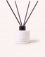 A reed diffuser bottle with a matte white cylindrical base and a black cap, featuring four black reeds extending upward. The brand name 'CANOPY HOME' is printed on the front of the bottle against a light beige background.