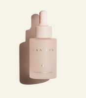 Pink skincare dropper bottle labeled 'CANOPY' on a light beige background